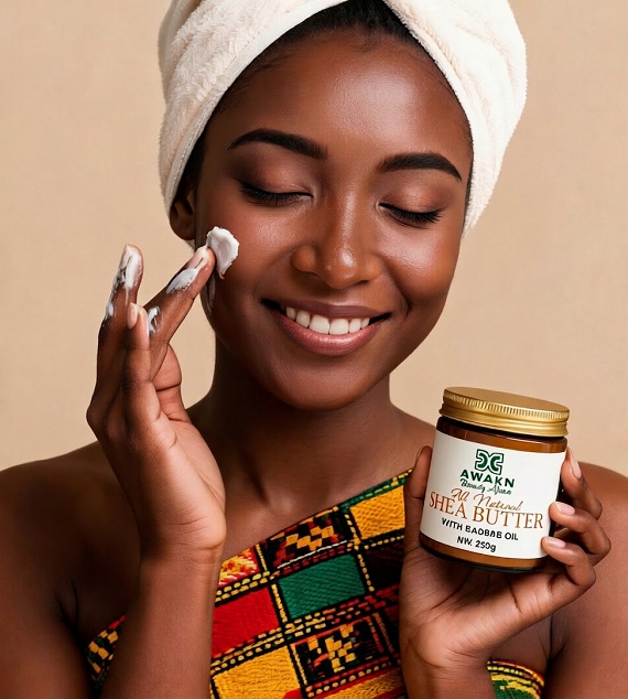 Awaken Beauty Africa model applies shea butter on her face.